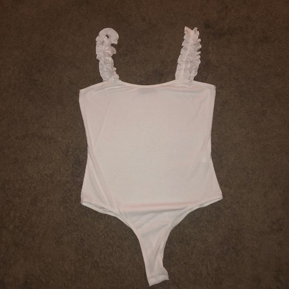 white body suite with ruffled straps.